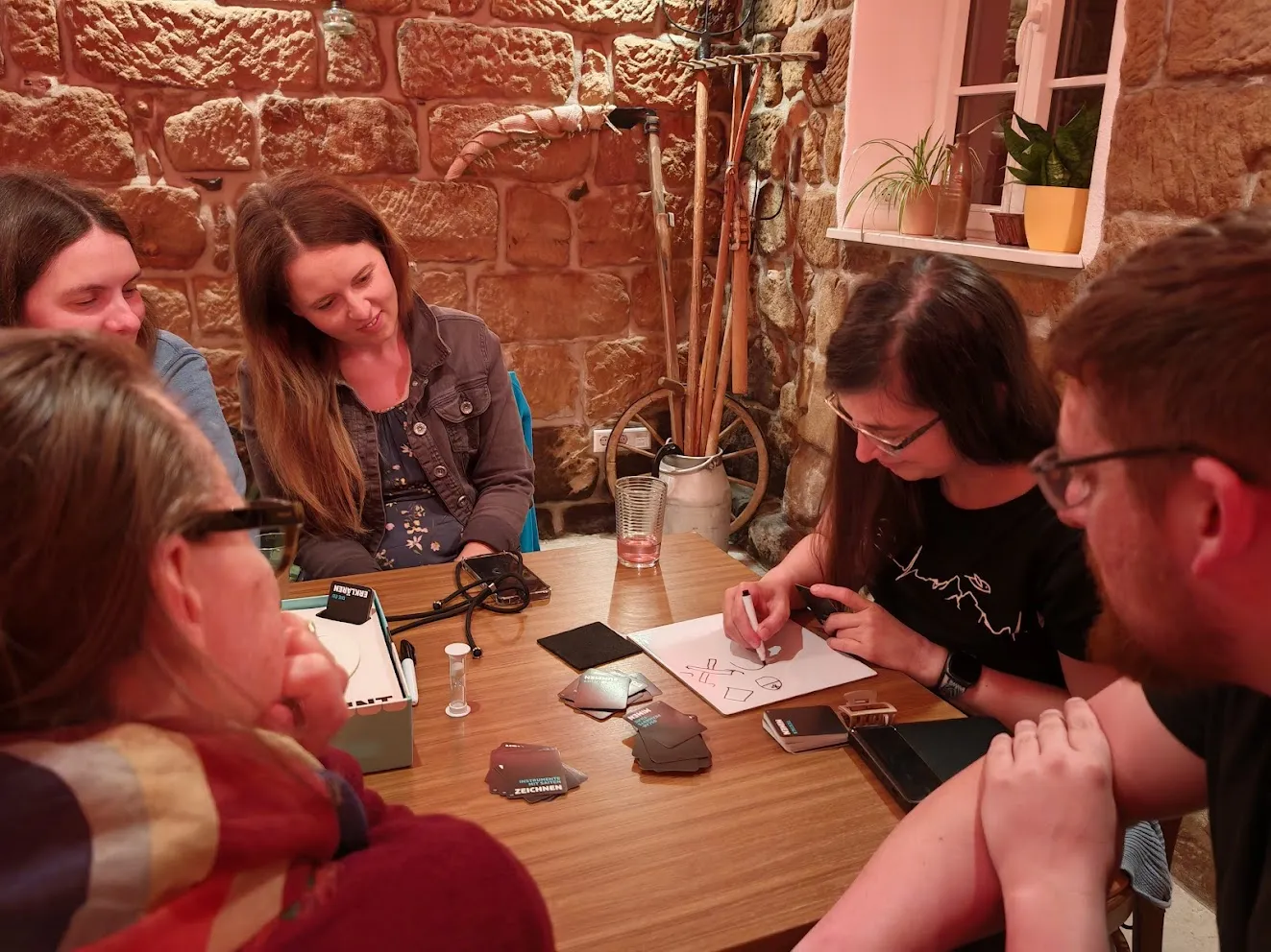 Fröhliche Spielrunde an einem Holztisch in gemütlicher Runde